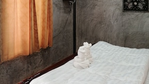 Une chambre à coucher comprenant un lit, des rideaux, un téléviseur à écran plat, un climatiseur et un tableau accroché au mur.
