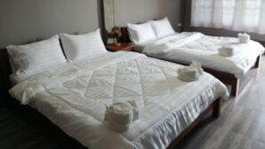 Une chambre d’hôtel avec deux lits, du linge de lit blanc et une fenêtre avec des rideaux.