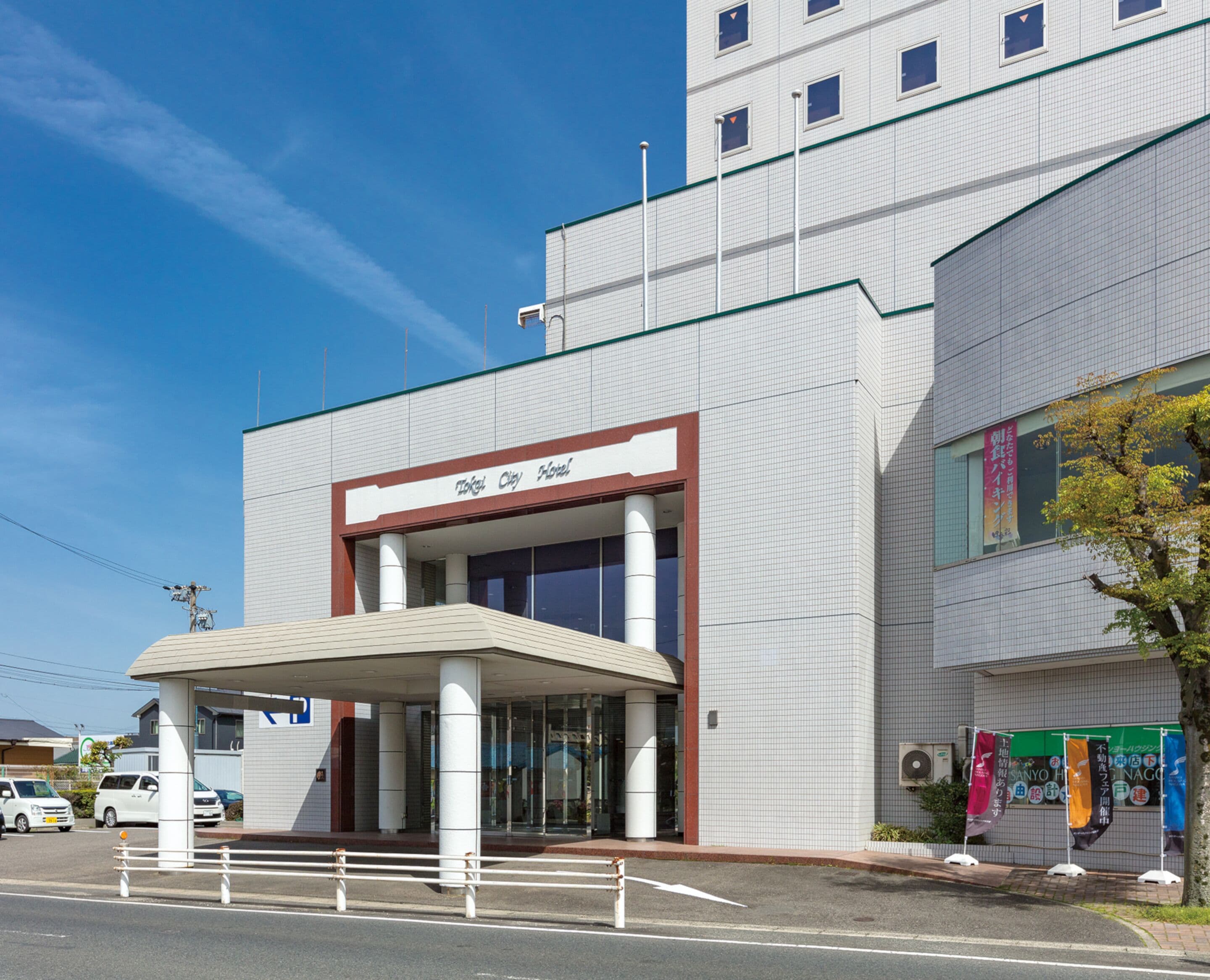 A modern hotel with a prominent entrance, large windows, and a tiled facade.