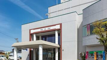 A modern hotel with a prominent entrance, large windows, and a tiled facade.