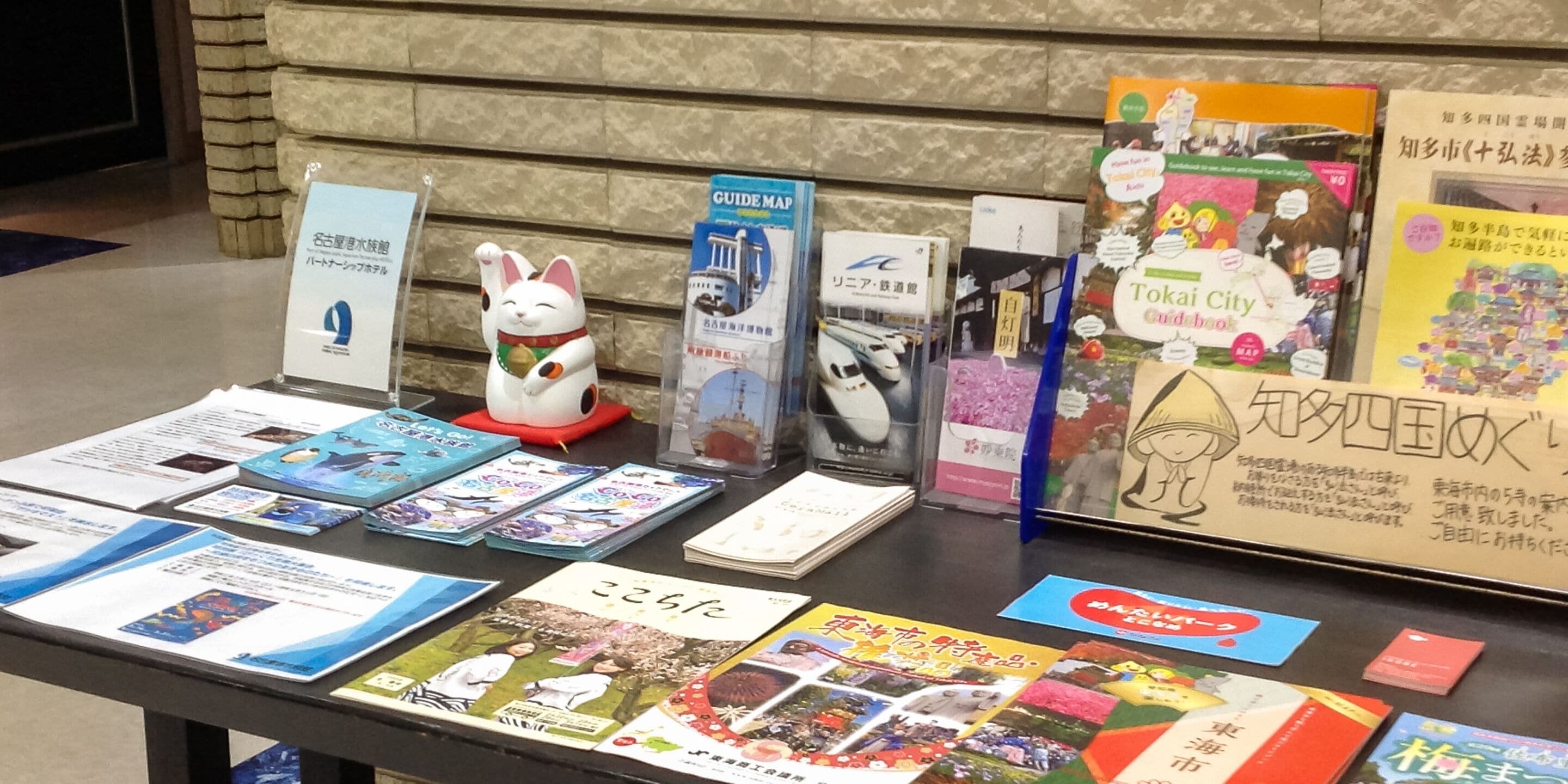 Una mesa con varios folletos de viajes y material informativo, incluyendo un mapa turístico y un libro sobre la ciudad de Tokio.