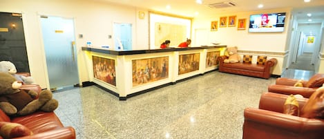 A reception area with a counter, seating, and a television.