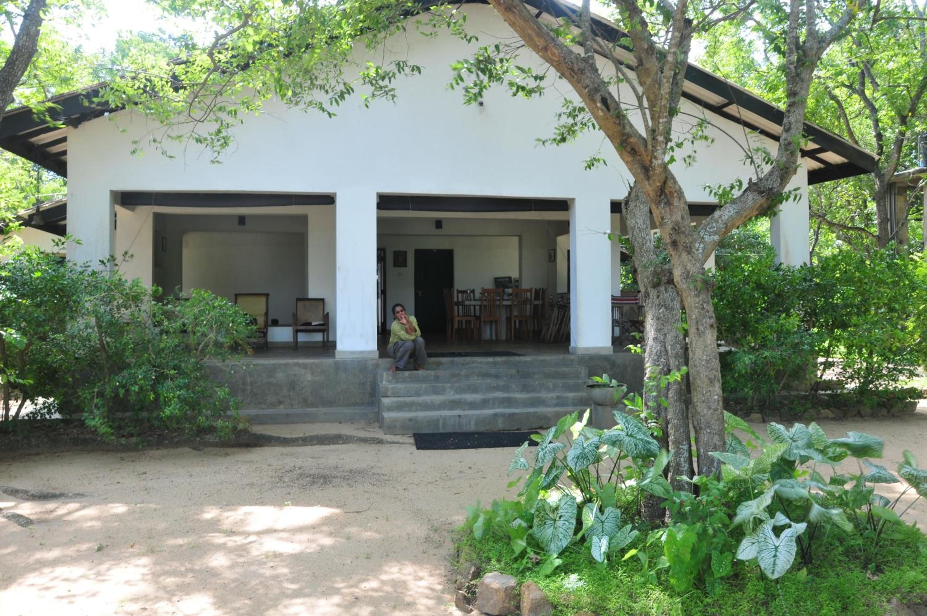 A two-story building with a covered porch and a staircase leading to the entrance.