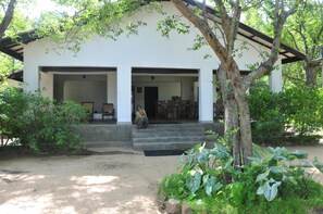 A two-story building with a covered porch and a staircase leading to the entrance.