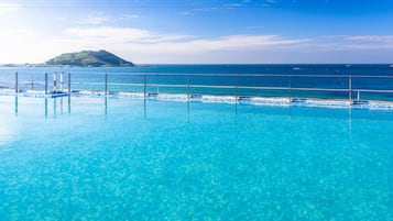 Una piscina al aire libre, sillones reclinables de piscina