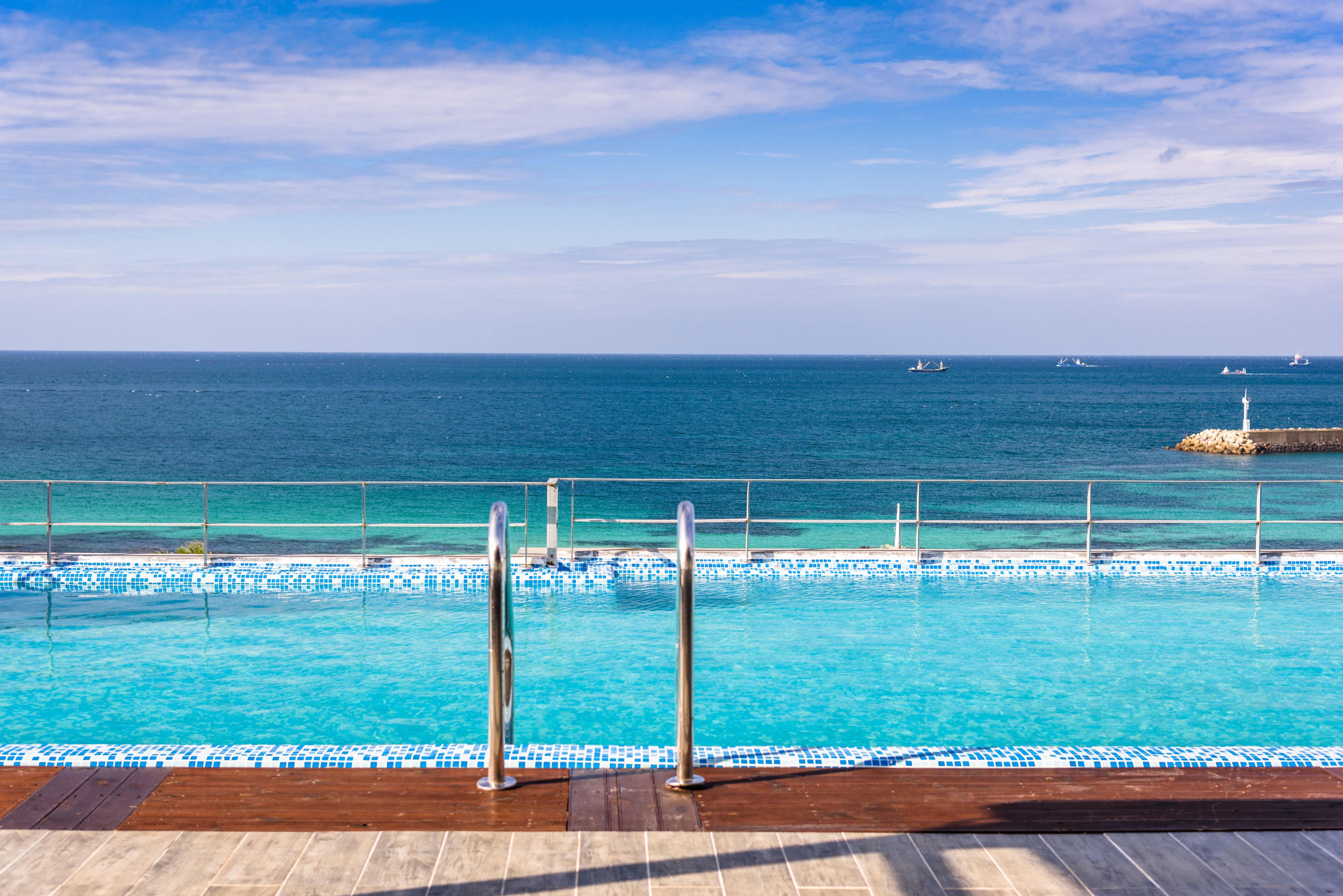 Una piscina al aire libre, sillones reclinables de piscina