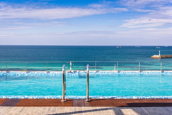 室外游泳池，開放時間為 09:00 至 20:00，提供日光浴躺椅