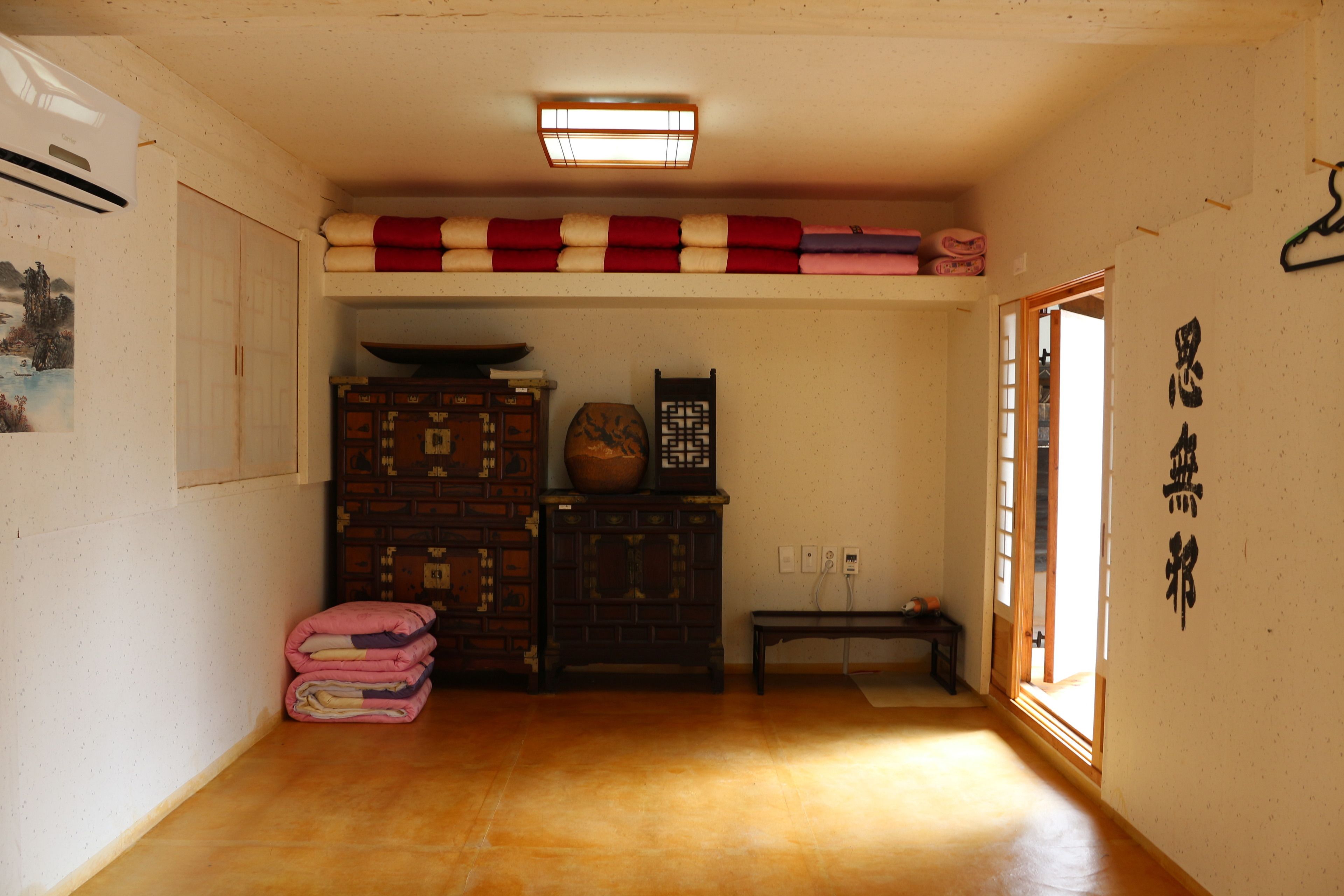 A traditional Japanese room with tatami flooring, a shoji screen door, and a hanging shoji.