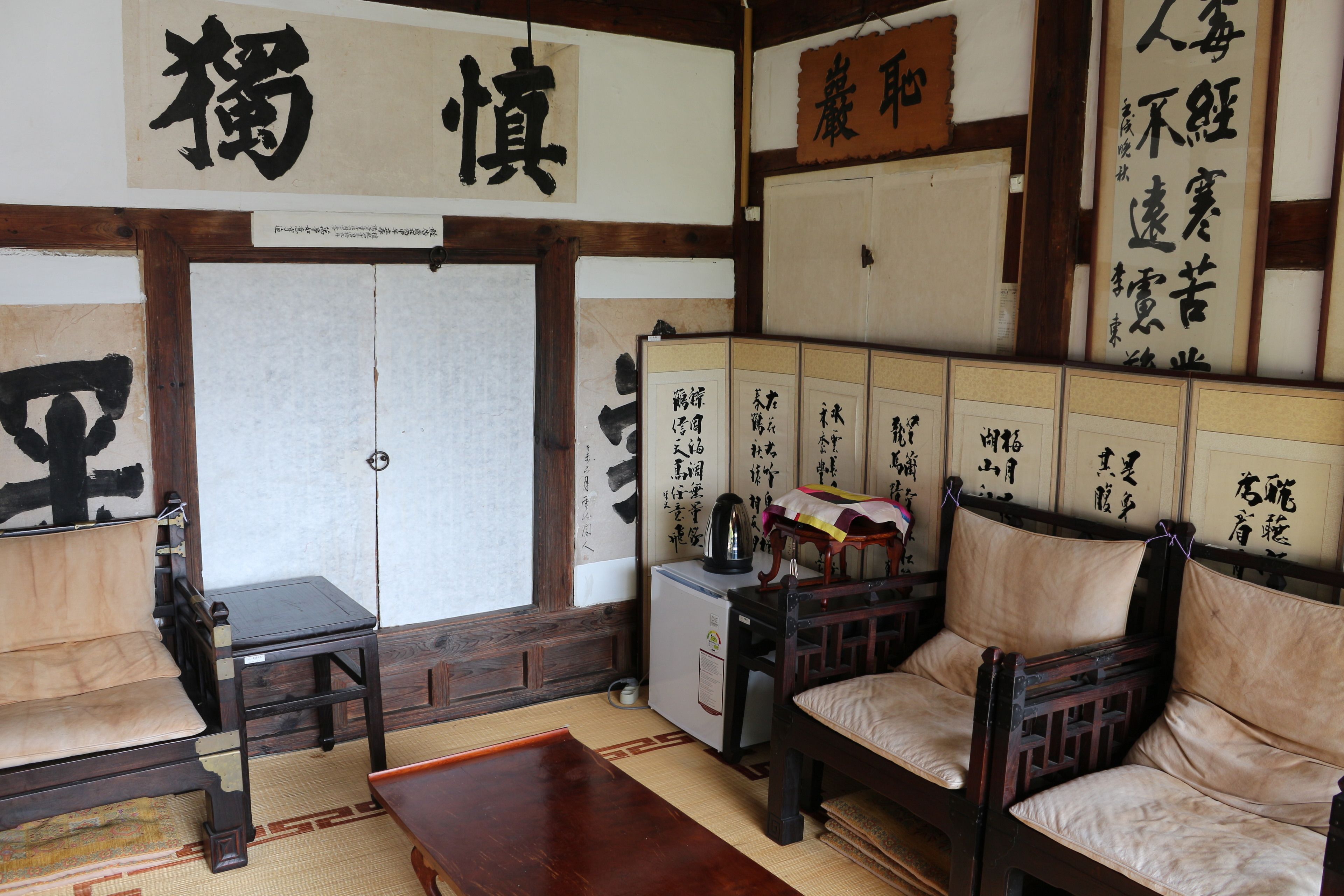 A traditional Japanese room with tatami flooring, a low wooden table, and a sofa.