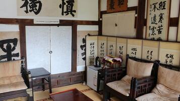 A traditional Japanese room with tatami flooring, a low wooden table, and a sofa.