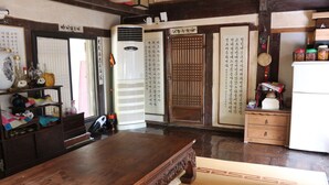 A traditional Japanese room with tatami flooring, a wooden table, and a sliding door with calligraphy. - Chiam Gotaek (Andong)
