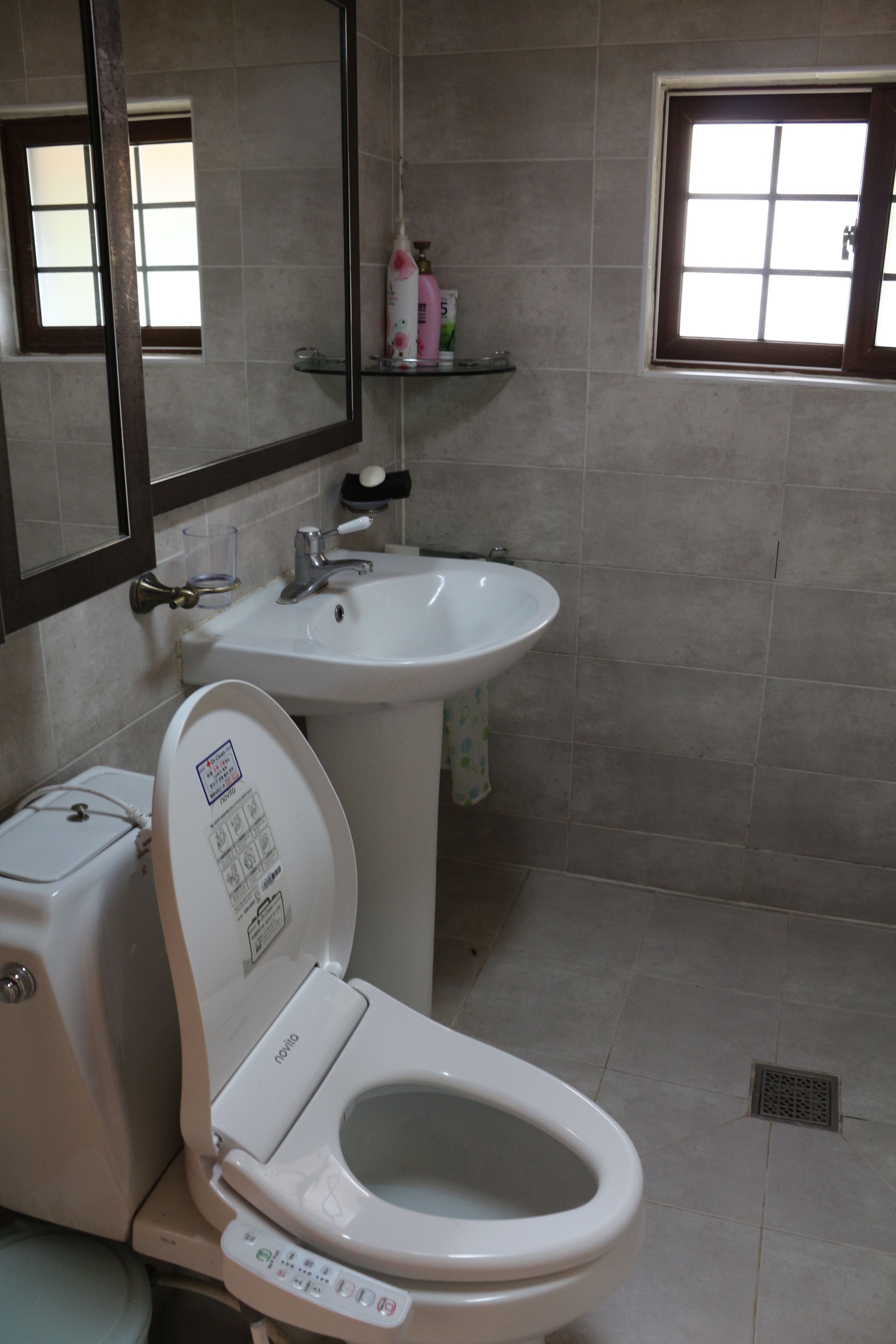 Un baño con inodoro, lavabo y espejo.