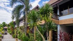 Un resort con edificios de varios pisos, un camino pavimentado y abundante vegetación tropical.