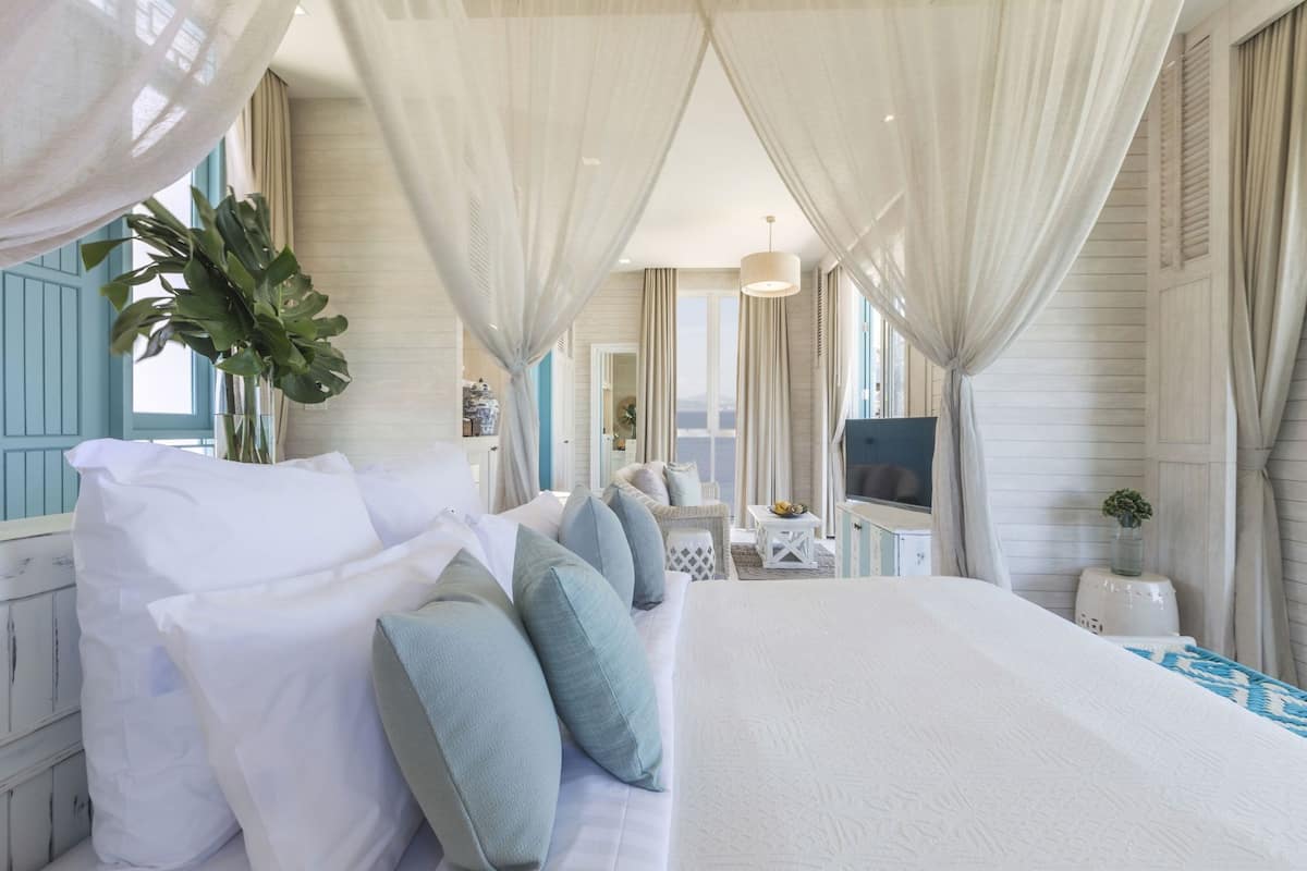 Une chambre spacieuse avec un grand lit, une télévision et une vue sur la mer.