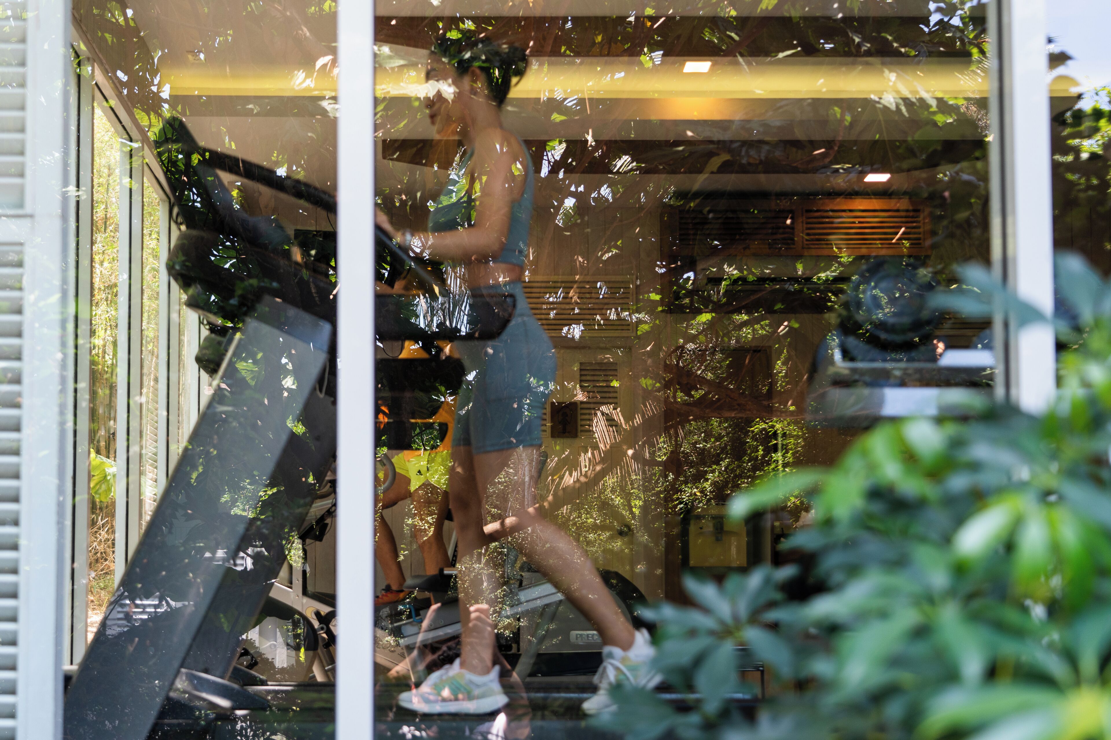 A person on a treadmill inside a room with a window.