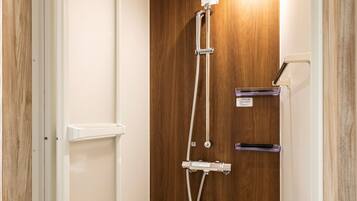 A wooden door with a shower control panel and a handrail.