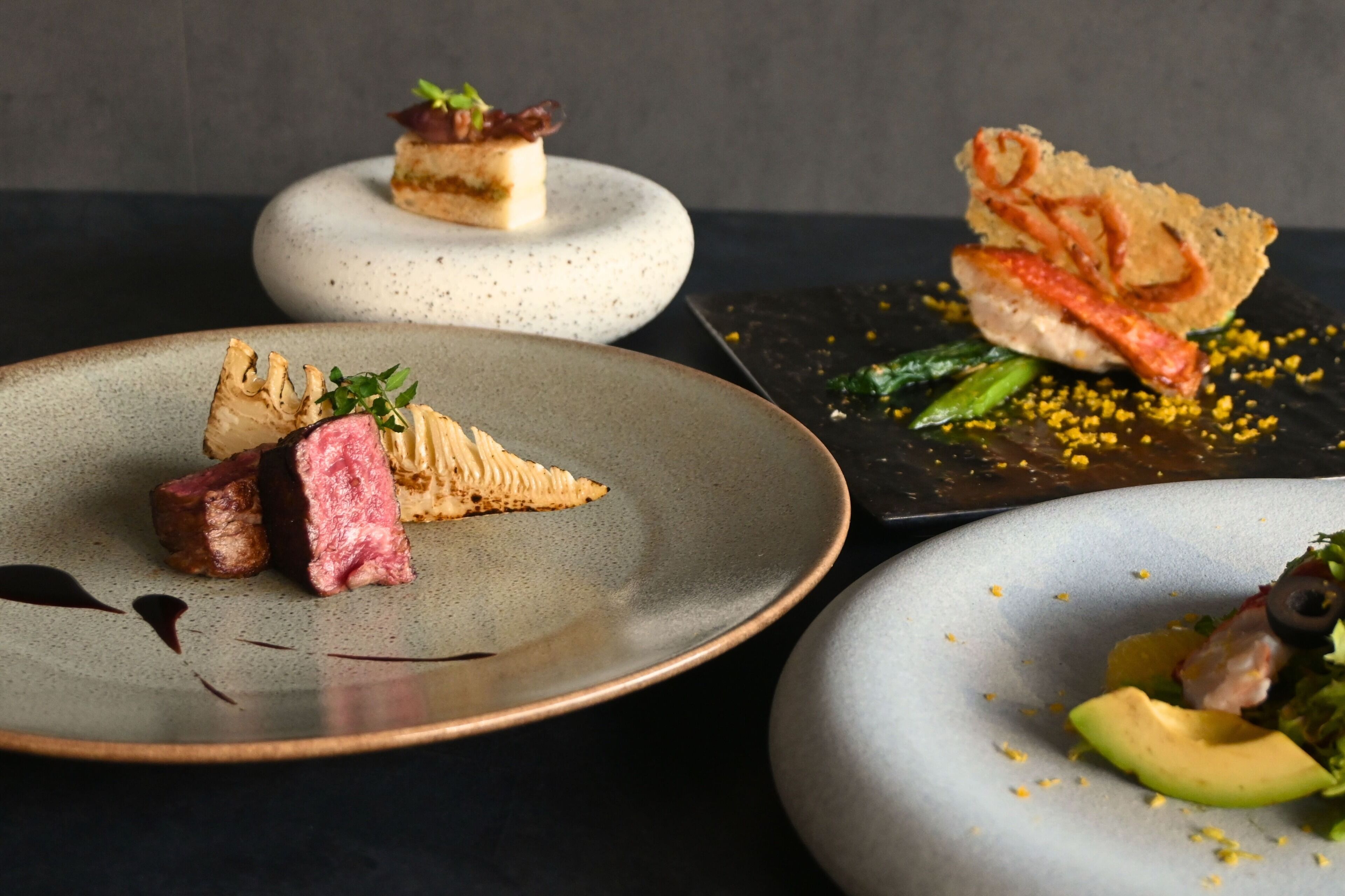 Three plates of food with various dishes.