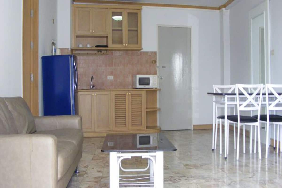 Un espacio habitable compacto con kitchenette, comedor y zona de estar.