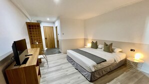Una habitación de hotel moderna con cama, mesita de noche, escritorio y silla.
