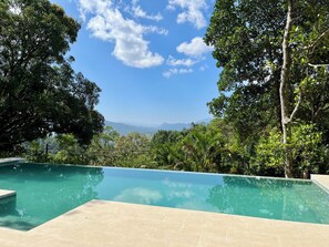 A swimming pool with a clear view of the mountains in the background. - Amandari Holiday Villa (Kandy)