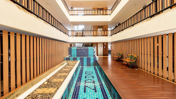 A multi-level indoor swimming pool with wooden railings and tiled flooring. - Grannylla Residence Charoenkrung (Bangkok)