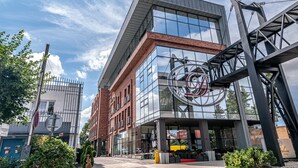 A modern building with a glass facade, a prominent logo, and a metal structure. - Hotel Dolphin (Senec)