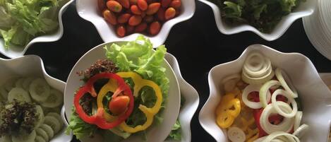A table with various bowls containing different salads and vegetables.