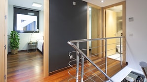 A modern hotel room with a wooden floor, a black accent wall, and a metal railing. - MSB Pool with Terrace (Barcelona)