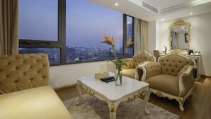 Amplia sala de estar con un ventanal que ofrece vistas de la ciudad, un sofá cómodo, una mesa de centro y un espejo decorativo.