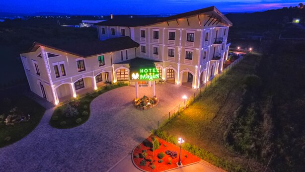 Un hotel con un patio central, varios balcones y una entrada bien iluminada.