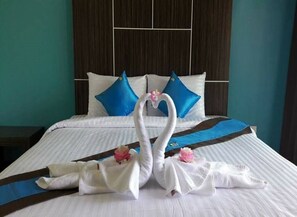 A hotel room with a neatly made bed, a large window, and a dark wooden headboard. - P' Private Resort Cha Am (Cha-am)