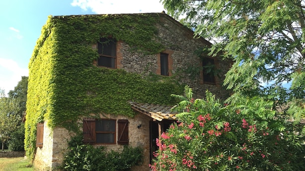 A stone building with ivy covering its exterior walls, a wooden door, and a small porch with a roof. - Agriturismo Podere Conte Ràcani (Amelia)