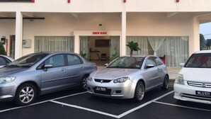 A parking lot with three cars parked in front of a building with a sign reading "NORTH BLOCK".