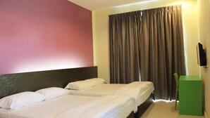 A hotel room with two beds, a green side table, a television, and a large window with curtains.