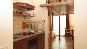 Una cocina con armarios de madera, estufa y cafetera.