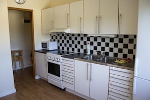 Apartamento familiar, 1 habitación, cocina | Cocina privada | Frigorífico, microondas (previa solicitud) y cafetera o tetera