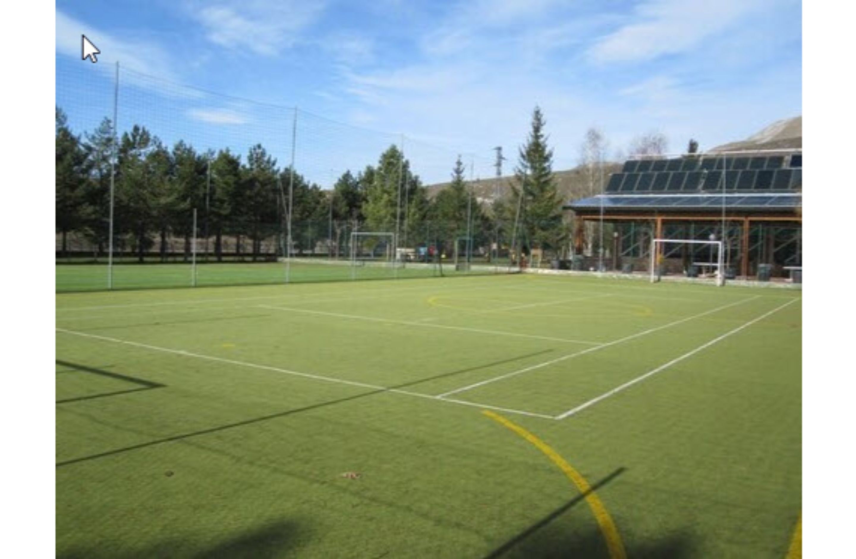 A sports field with goalposts and a building with solar panels.