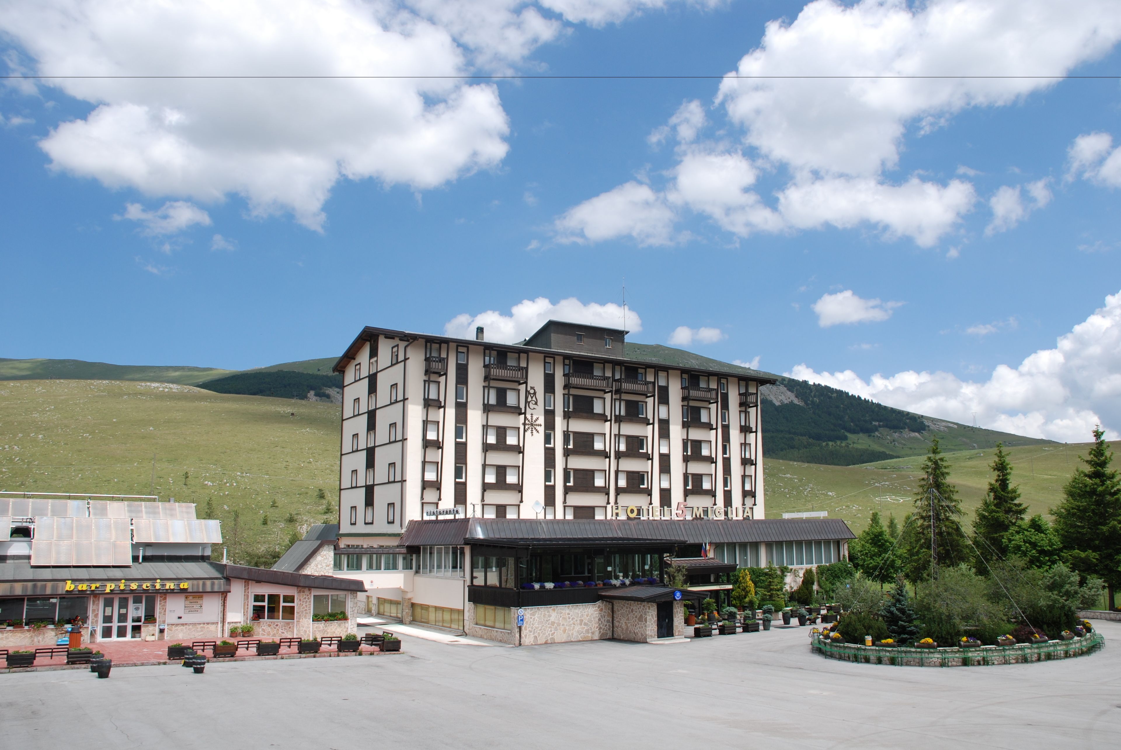 Un hotel moderno a più piani, con un'ampia hall di ingresso e un'area dedicata al parcheggio.