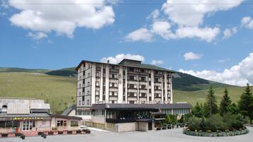 Un hotel moderno a più piani, con un'ampia hall di ingresso e un'area dedicata al parcheggio.