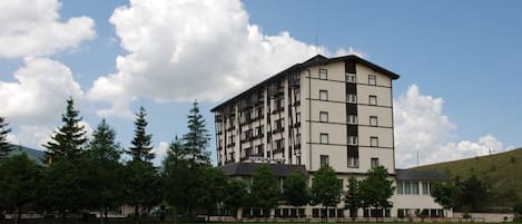 Un edificio de varios pisos con techo plano y un balcón en el segundo nivel.