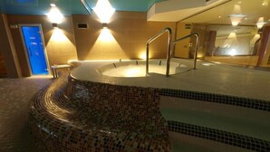 A spa area with a mosaic-tiled hot tub, metal railings, and warm lighting. - Hotel Felisa Spa (Santillana del Mar)