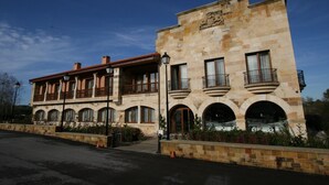 A two-story building with a stone facade, multiple balconies, and arched windows. - Hotel Felisa Spa (Santillana del Mar)