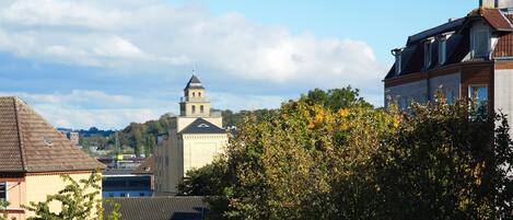A building with a prominent tower, surrounded by trees and other buildings.