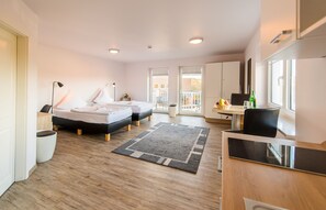 A modern hotel room with two beds, a desk, a chair, and a balcony. - Hotel Flensburg Akademie (Flensburg)