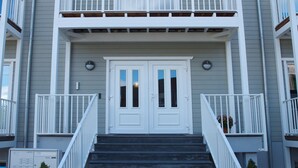 A two-story building with a front entrance, double doors, and a staircase leading to the entrance.