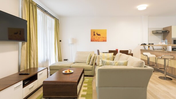 Een moderne woonkamer met een bank, salontafel en een flatscreen televisie.