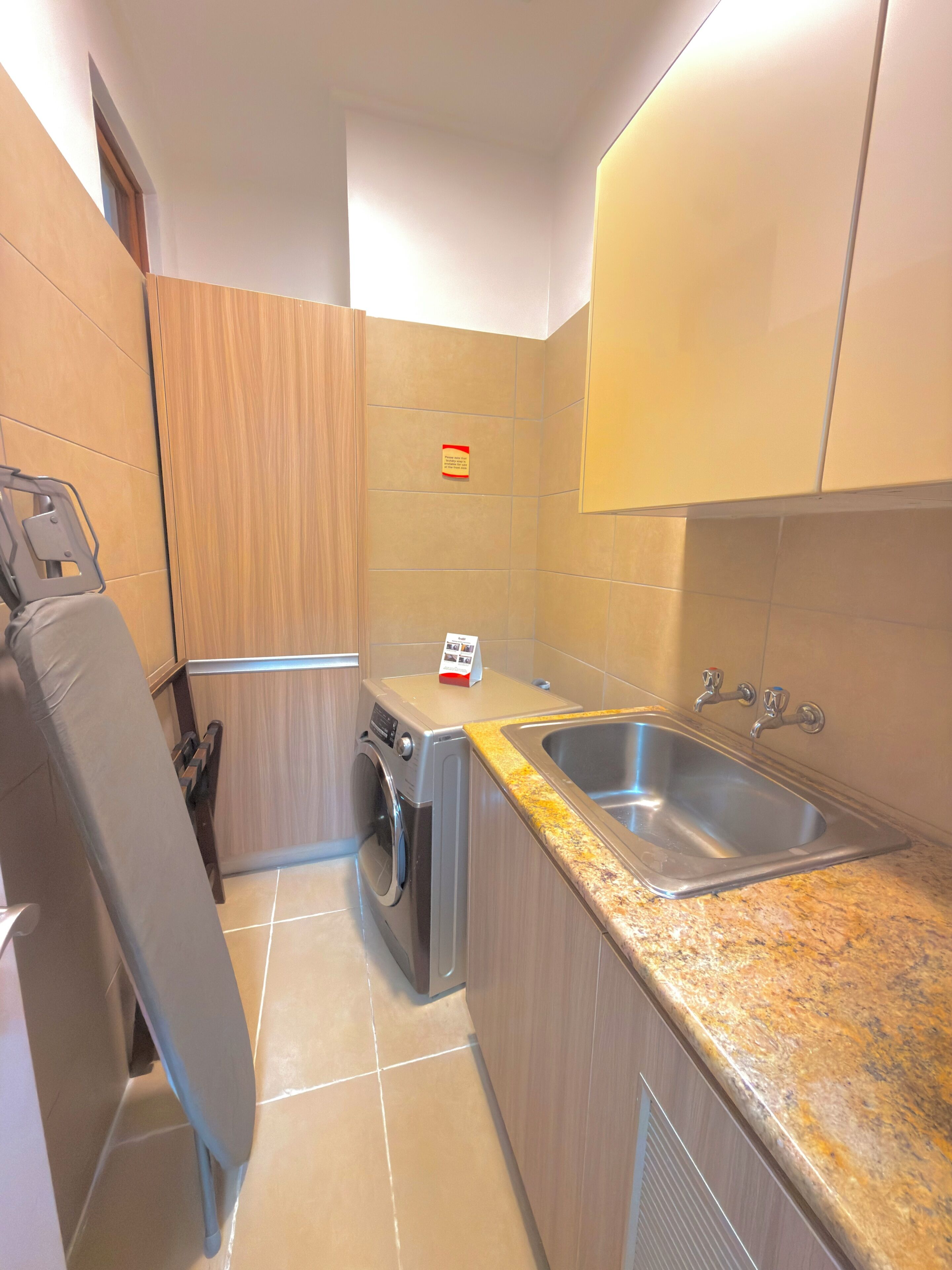 Cocina compacta con lavadora, pileta y mesada.