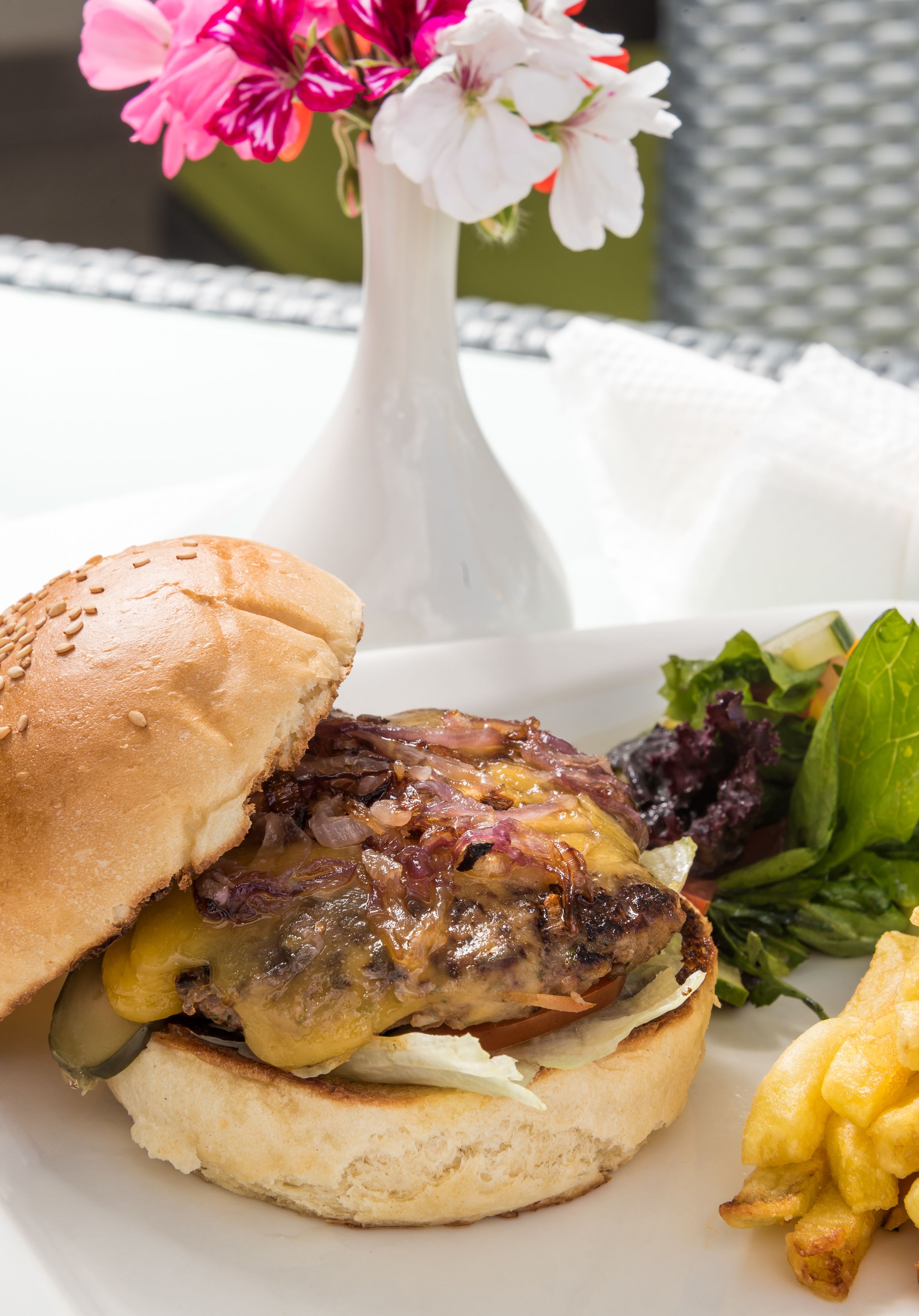 Un sandwich accompagné d’une portion de frites et d’une salade, le tout servi sur une assiette blanche.