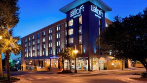 A modern hotel building with a prominent sign, multiple floors, and a well-lit entrance. - Aloft by Marriott Columbia Downtown (Columbia)