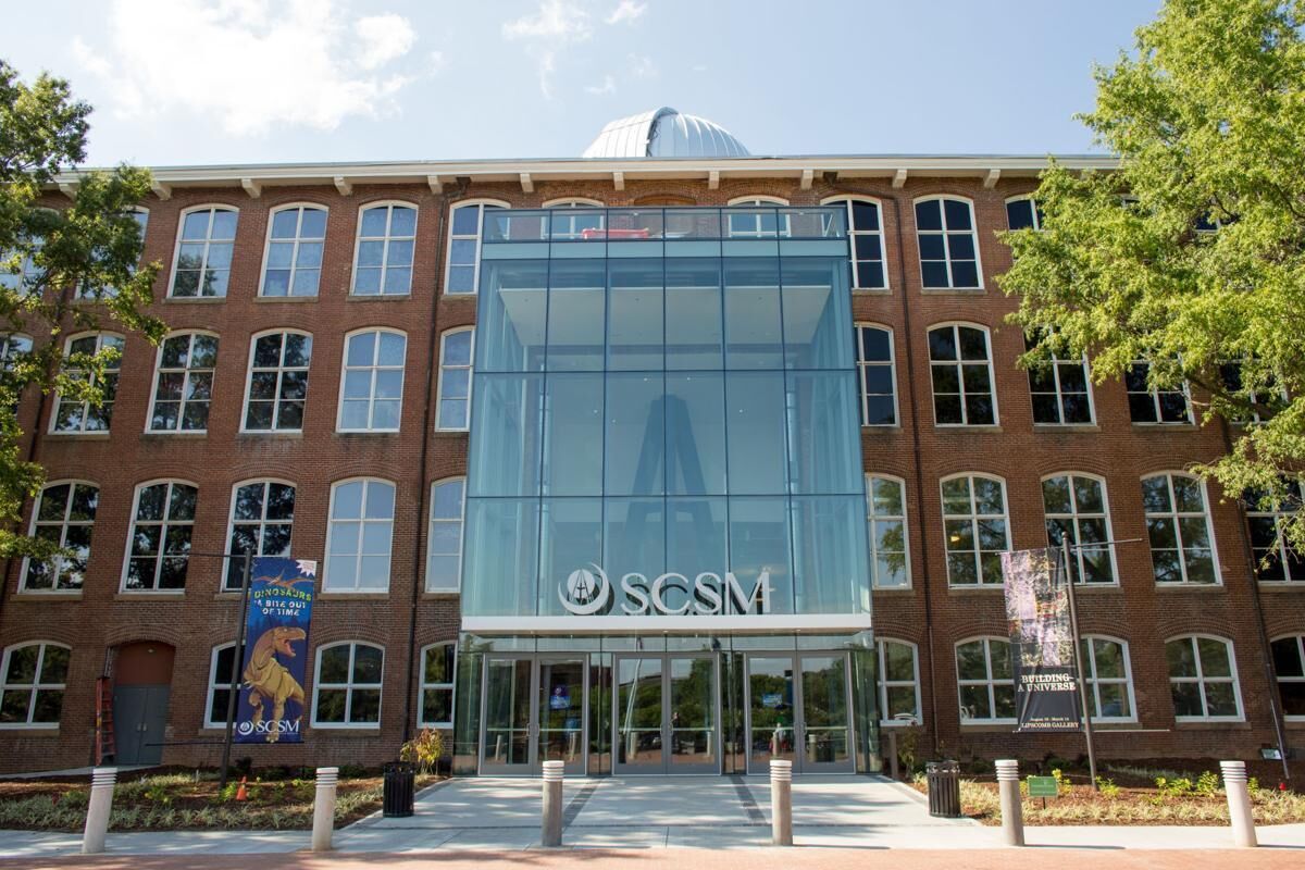 A building with a glass facade and the logo 'SCSM' on the entrance.